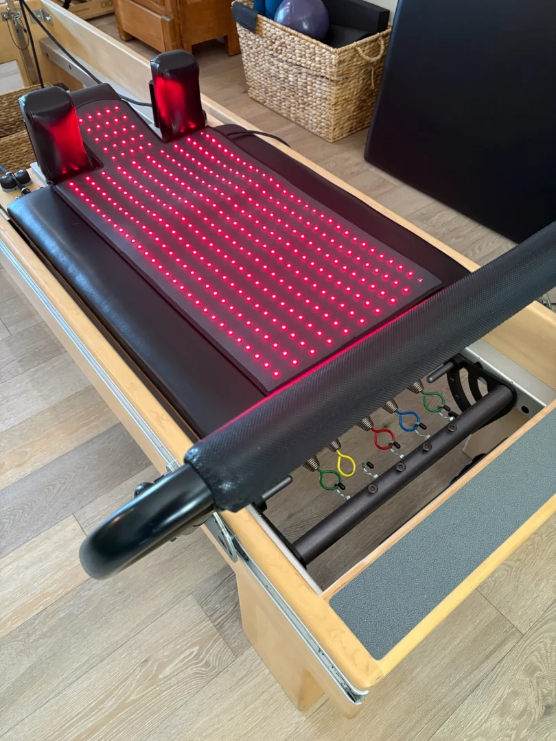 Reformer carriage fitted with a red light therapy recovery pad